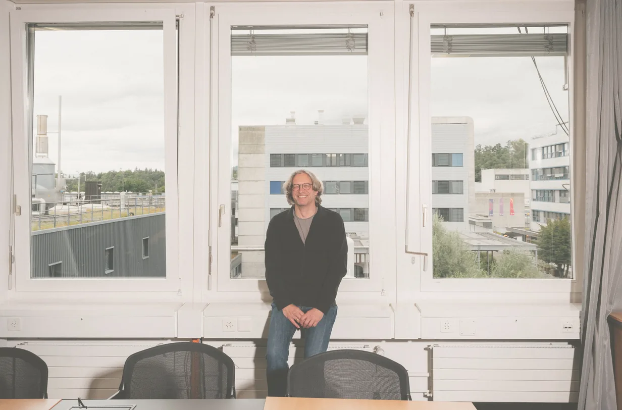 Andreas Pautz steht vor einer Fensterfront in einem Besprechungsraum am Paul Scherrer Institut.